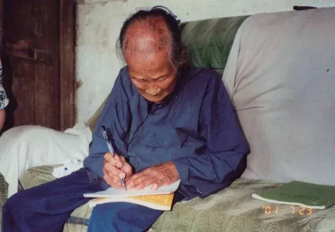 Die Nüshu-Traditionsträgerin Yang Huanyi beim Schreiben.